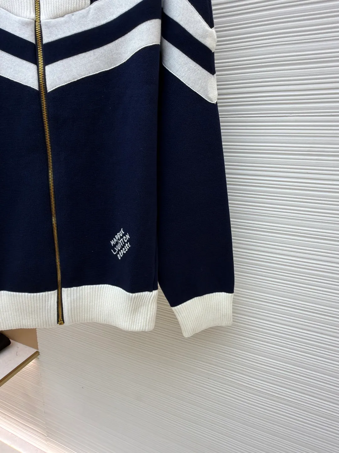 LOUISVUITTON line-tone embroidered jacket ●Original version: purchased and developed in 19899 ●Item number: 1680861-B75 ●Fabric: combed cotton fabric ●Technology: embroidery production ●Version: fitted version ●Weight: about 965 grams ●Size: S-M-L-XL ●Description: The yarn is made of [2/40 count 100% combed cotton], It is made of [14-needle computer woven piece], the whole piece is solid sesame base, [about 160 minutes], the blue and white strips are [hair hanging method], and the weaving time is longer [about 70 minutes]; when sewing, the hem ribs and cuff ribs need to be [stitched in double layers], the collar bone is wrapped so that it does not show up, [the collar needs to be sewn twice], the bottom bone and the shirt body bone are not in the same line When sewing the sleeves, you need to sew in a circle, which takes a long time to sew. After embroidering, you need to carve the blue and white strips of tape and the zipper. When flat sewing, you need to pay special attention to the straight position of the straps, which can easily become skewed. The zipper is [inside the rib position], and the collar is very high. It is difficult to sew the zipper. The entire production process requires too many steps, and the wool is white, so it is very easy to get dirty, which increases the finishing time and the defective rate. The overall wiring is straight and delicate, the fabric is comfortable and soft, and the color is consistent without color difference. It can be matched with the same style to create a fashionable look and control various occasions. Customized accessories, complete with three standards, same style for men and women!